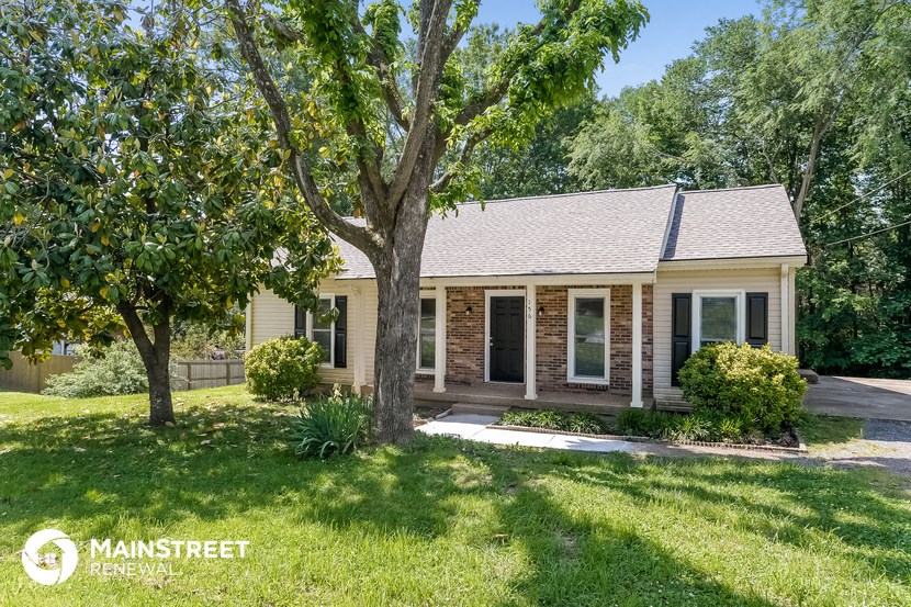 a small brick house with a tree in the front