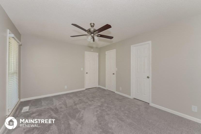 the spacious living room with ceiling fan