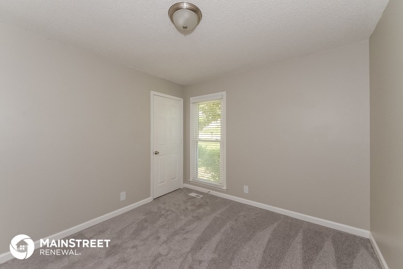 the interior of an empty room with carpet and a door