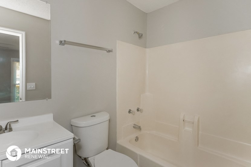 a white bathroom with a tub and a toilet and a sink