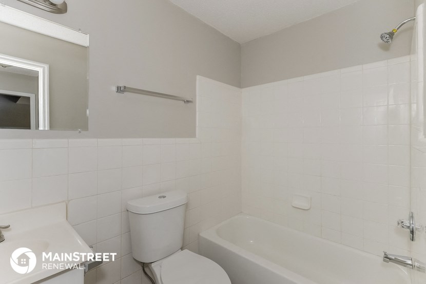 a bathroom with a toilet and a tub and a sink