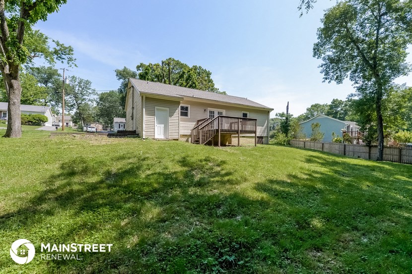 a house on a hill with a yard and a fence