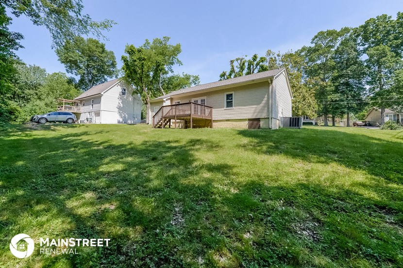 a large yard with a house and a car in the background