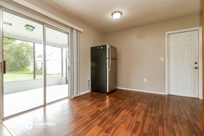 the living room of an empty house with a refrigerator