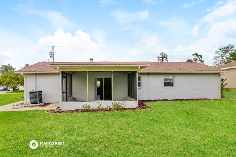 a small white house with a yard and a lawn
