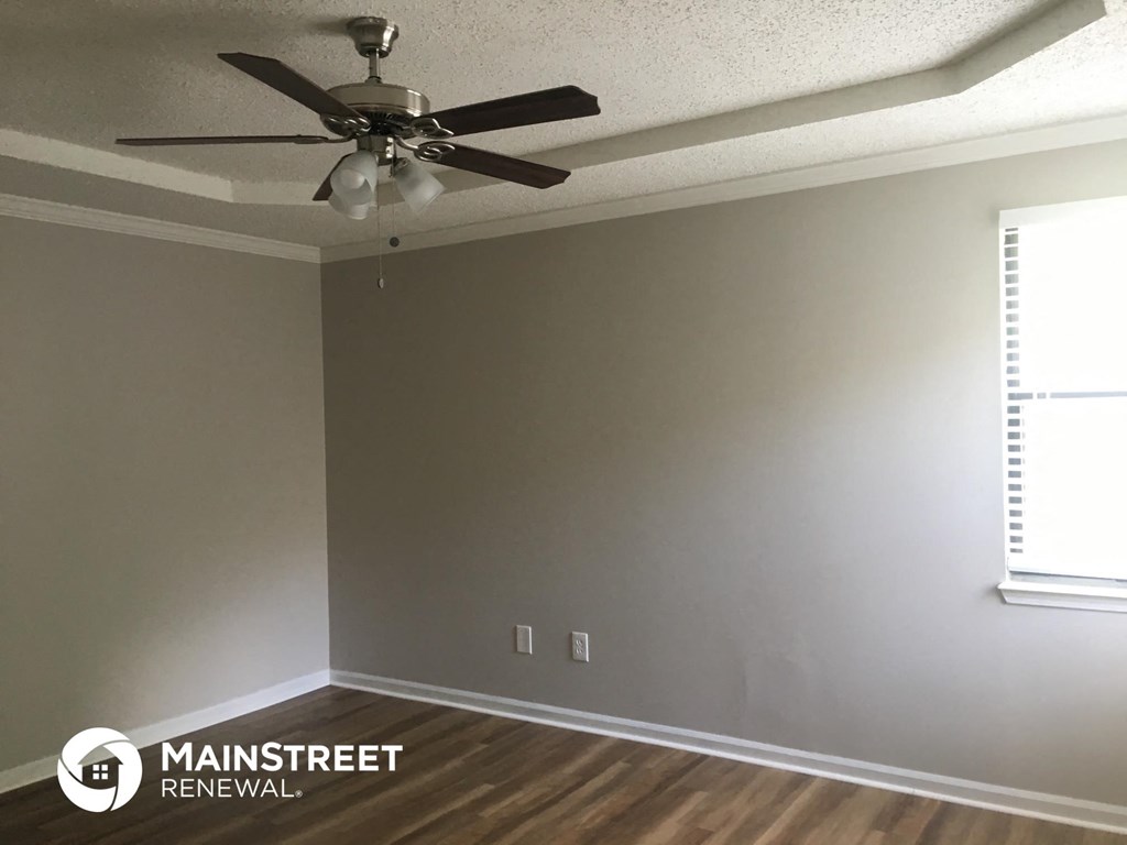 a living room with a ceiling fan and a window