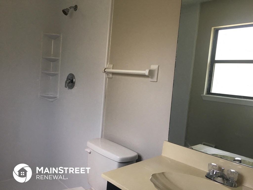 a bathroom with a toilet and a sink and a mirror