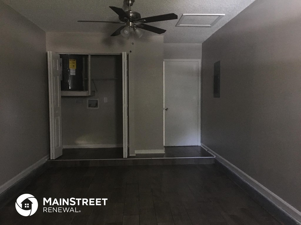 an empty room with a ceiling fan and a closet