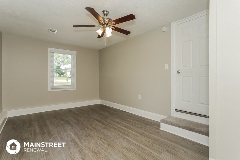 the living room of a renovated house with a ceiling fan