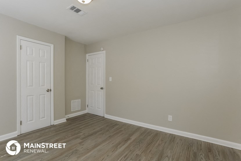 the interior of a room with two doors and wood flooring