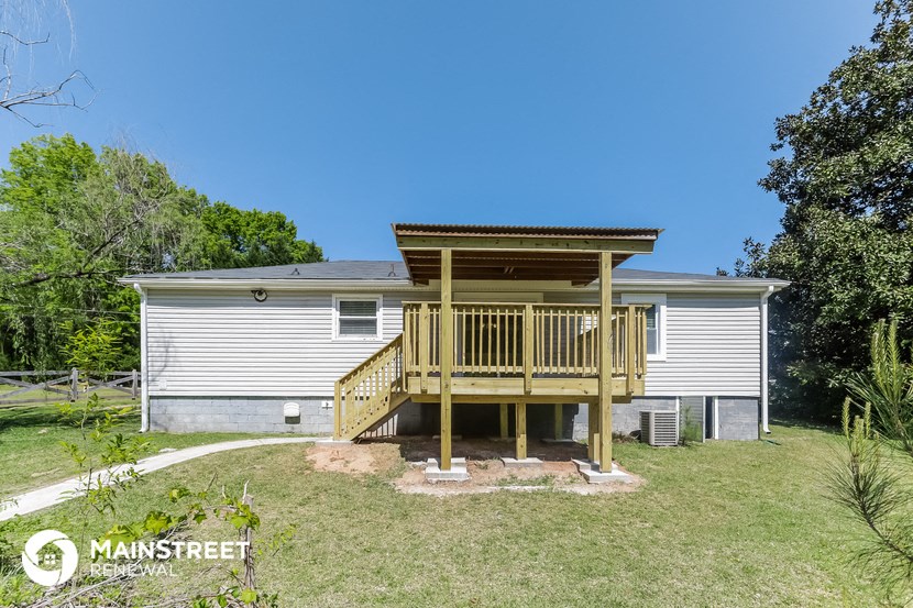 a small house with a deck on top of a yard