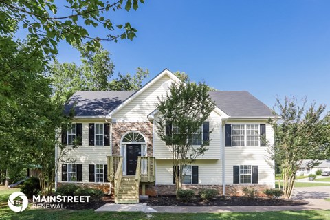 a white house with trees and a blue sky