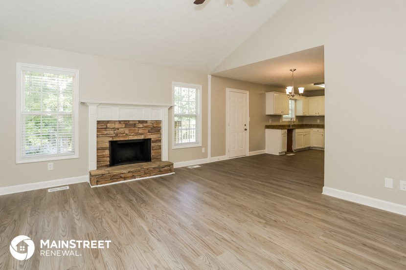 the living room and dining room of an open floor plan with a fireplace