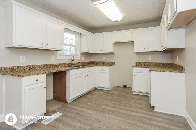a kitchen with white cabinets and a granite counter top and white