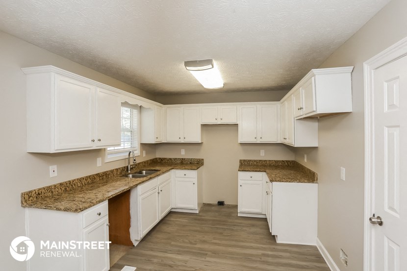 a kitchen with white cabinets and granite counter tops