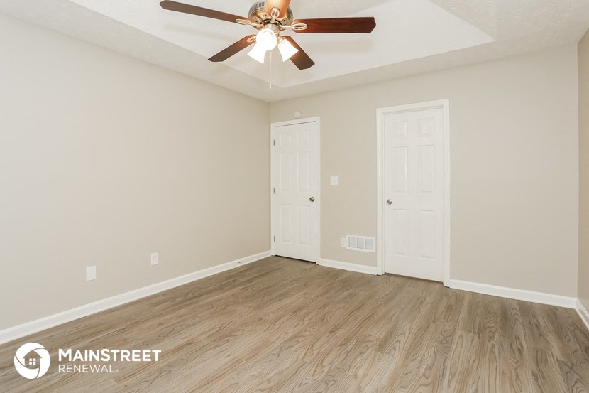 the living room of an empty renovated house with a ceiling fan