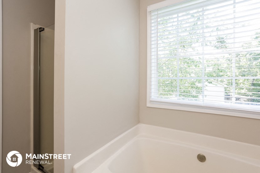 a small bathroom with a tub and a window