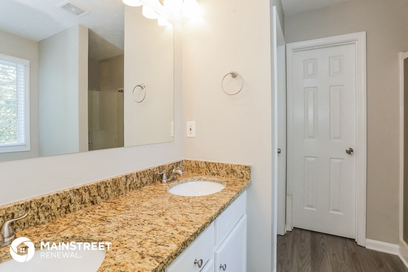 a bathroom with a sink and a mirror and a door