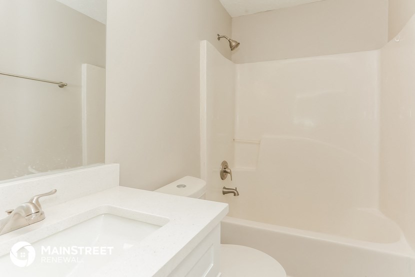 a white bathroom with a sink and a tub and a toilet