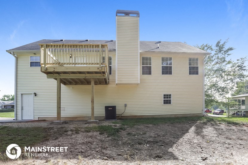 the view of the back of a house with a deck on top of it