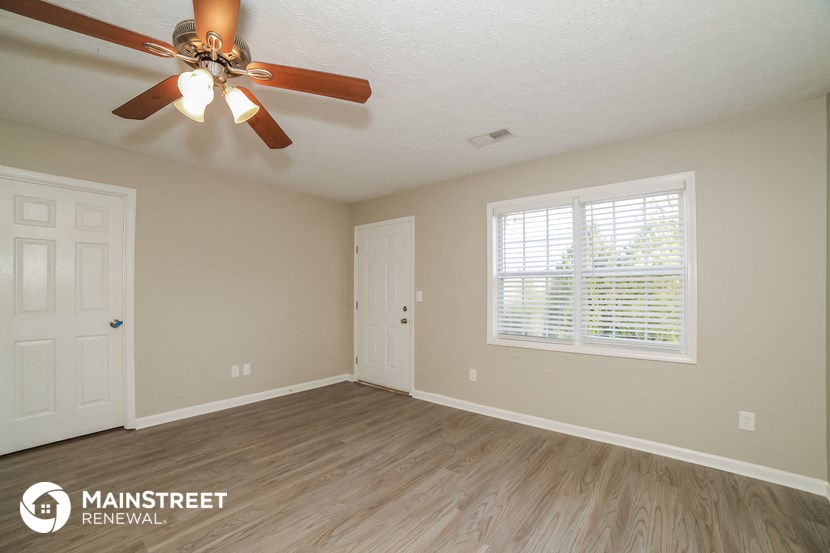 the living room of a house with a ceiling fan