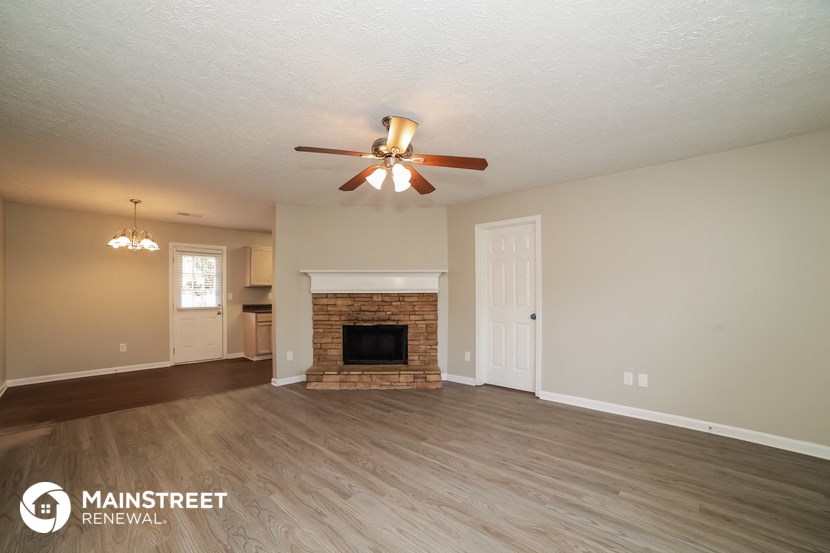 the living room with fireplace and ceiling fan