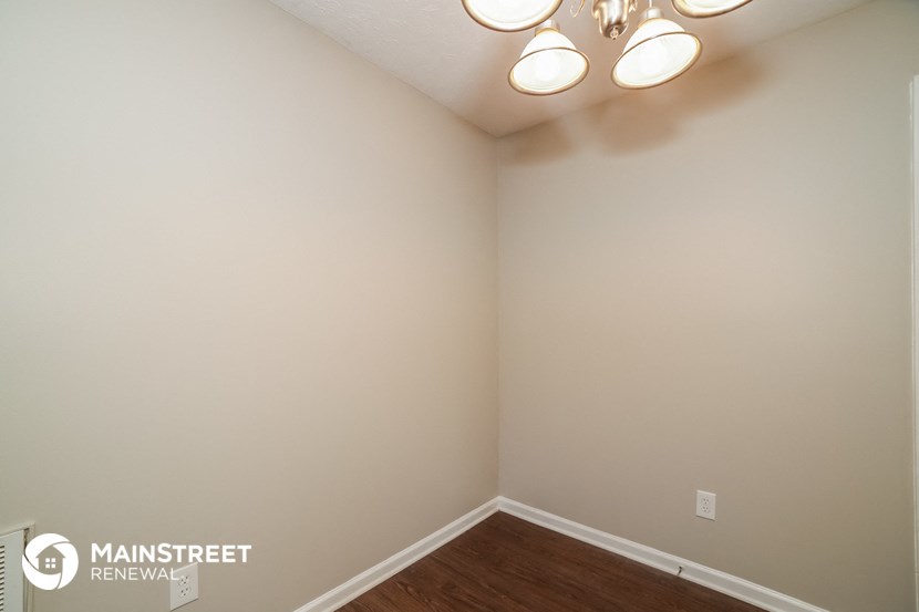 the interior of a bedroom with white walls and wood flooring