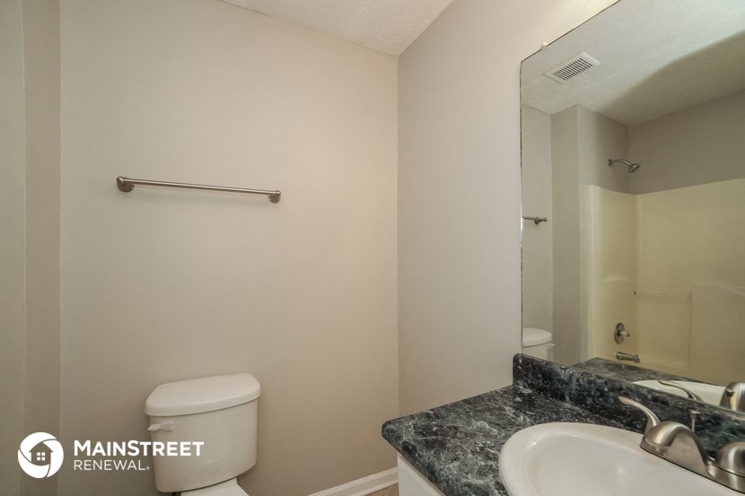 a bathroom with a sink and toilet and a mirror