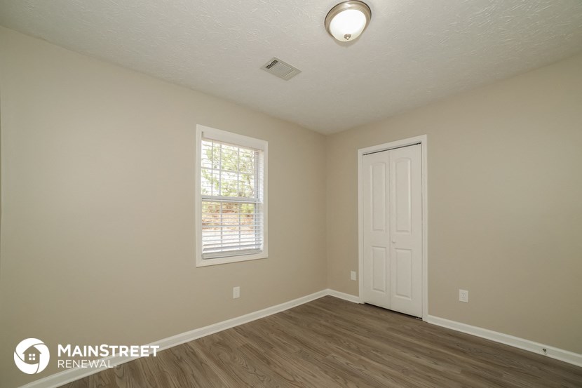 the interior of an empty room with a white door and a window