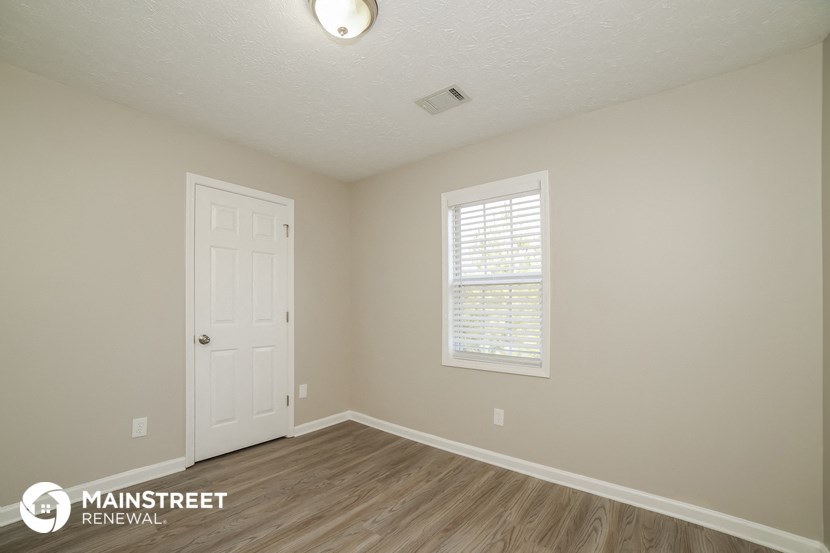 the interior of a bedroom with a door and a window