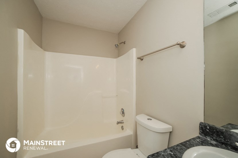 a bathroom with a shower and a sink and a toilet