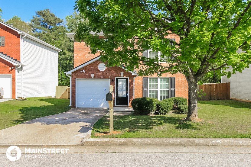 the front of a brick house with a blue garage door