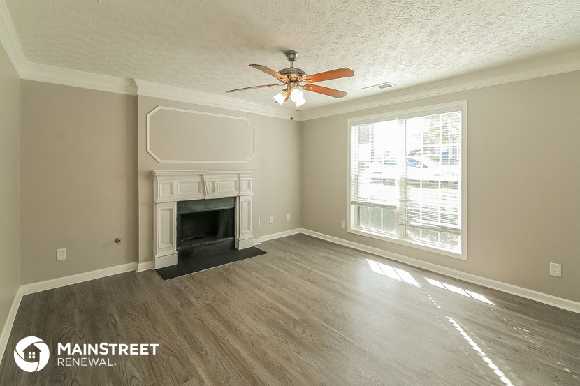 the living room with fireplace and ceiling fan