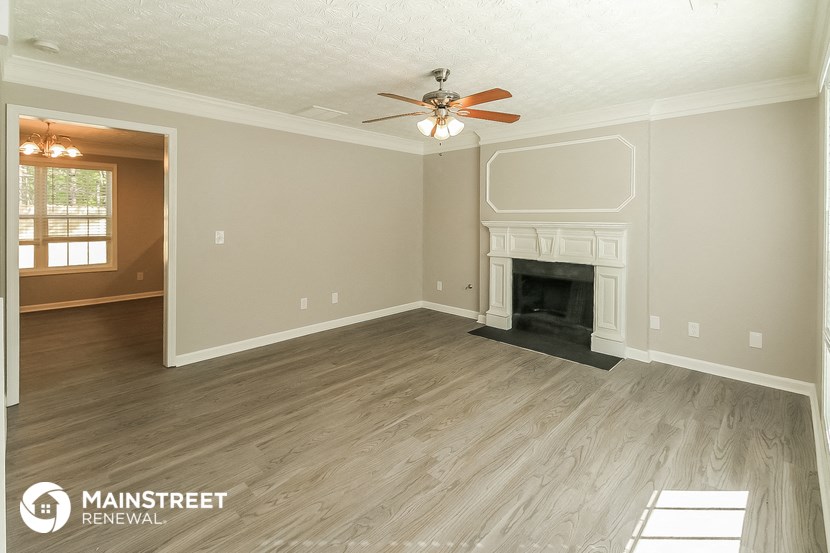 the living room after remodeling with wood flooring and a fireplace