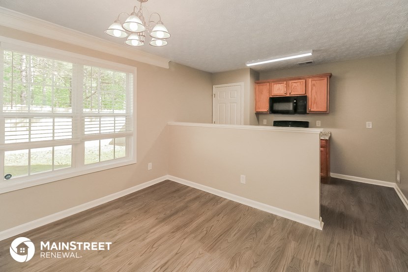 the kitchen and dining area of a renovated home with wood flooring