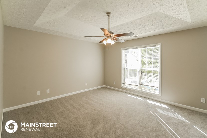 a living room with a ceiling fan and a window
