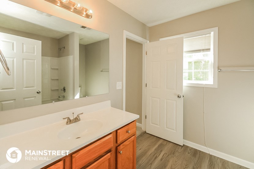 the master bathroom has a large mirror and a sink