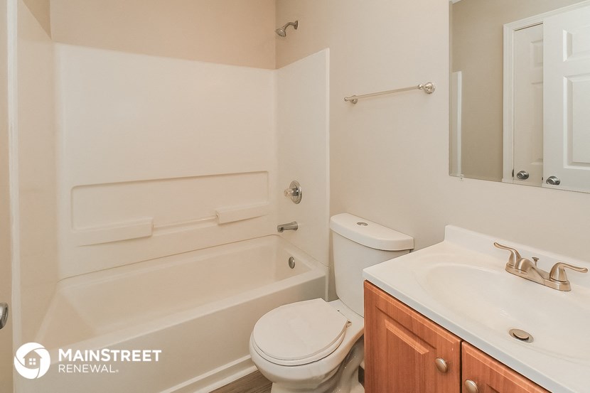 a bathroom with a toilet and a tub and a sink