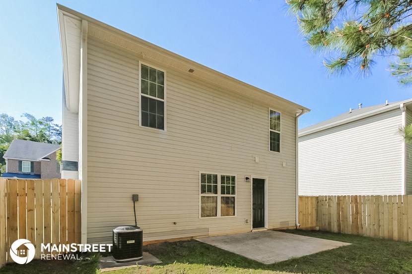 the outside of a house with a wooden fence and a driveway