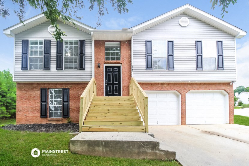 a white house with a wooden porch and a black door