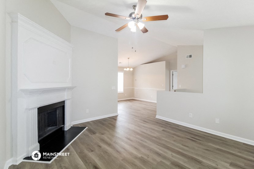 a living room with a fireplace and a ceiling fan