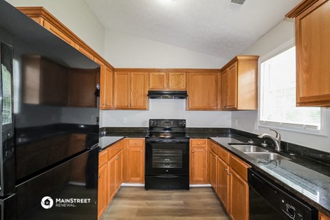 a kitchen with black appliances and wooden cabinets