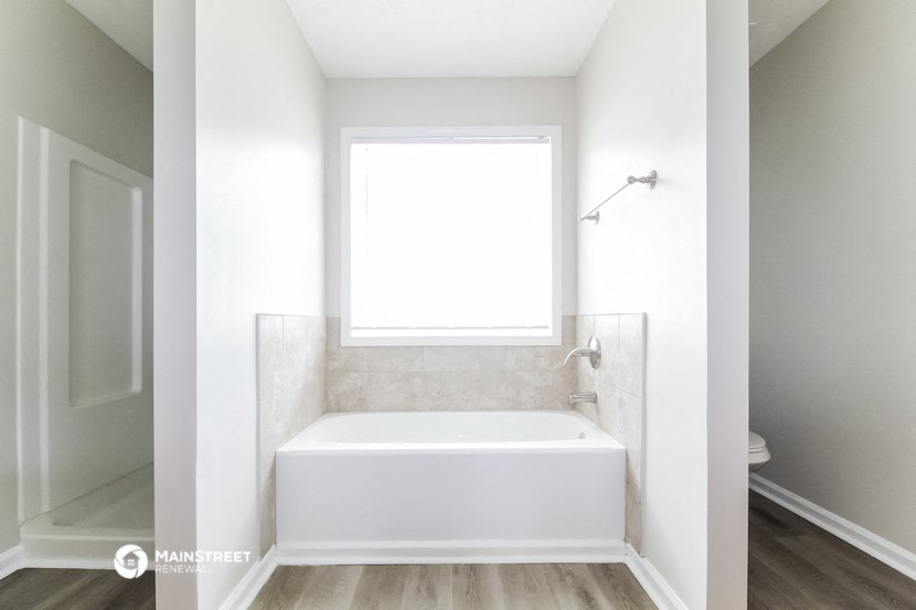 a renovated bathroom with a tub and a window