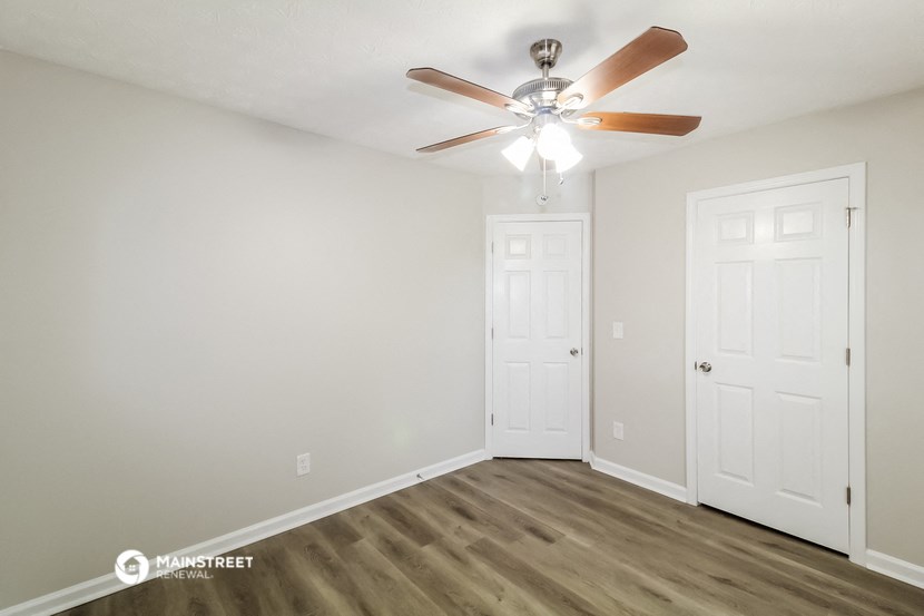 the living room of our studio apartment atrium with ceiling fan and door to bedroom