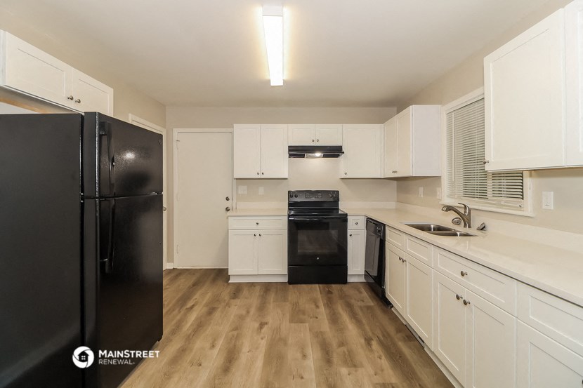 a renovated kitchen with black appliances and white cabinets