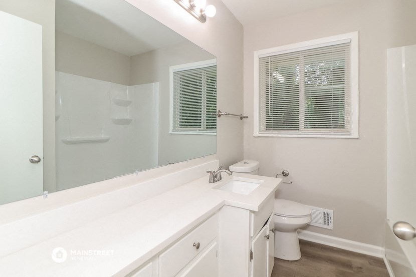 a bathroom with a large mirror and a toilet and a sink