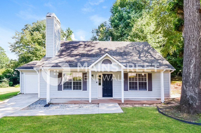 a small white house with a blue door and a lawn