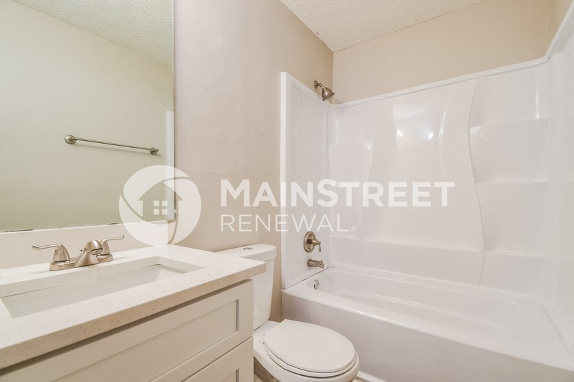 a renovated bathroom with a sink toilet and tub