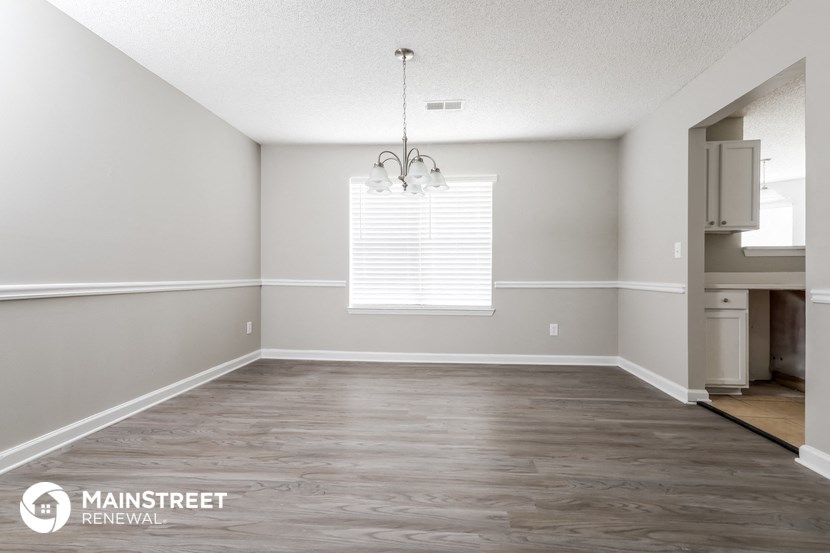 an empty living room with wood floors and a window