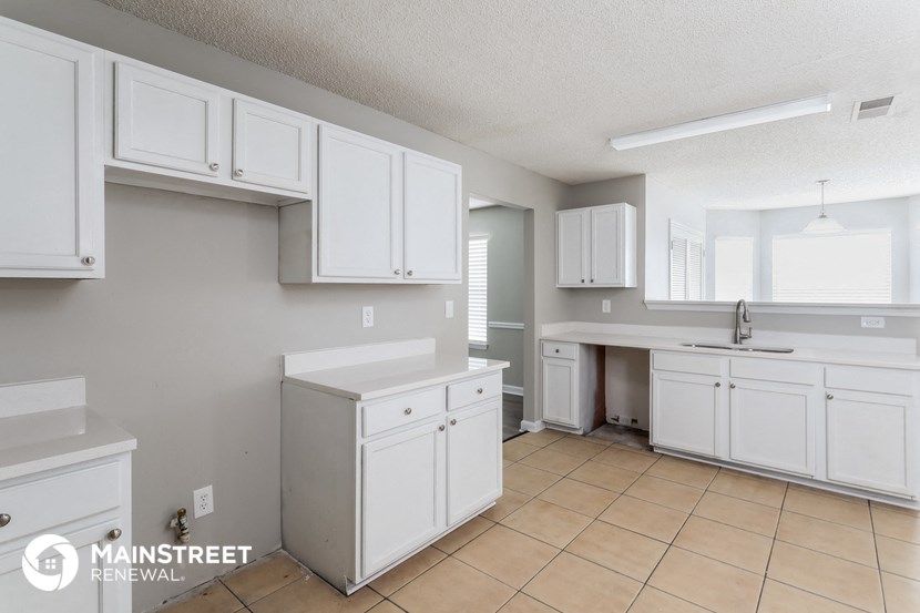 a kitchen with white cabinets and a sink and a counter